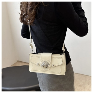 Vue détaillée du sac à bandoulière crème avec fermoir planète et rivets argentés