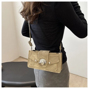 Detail of vintage khaki crossbody bag with unique metallic knob lock and side flap pockets