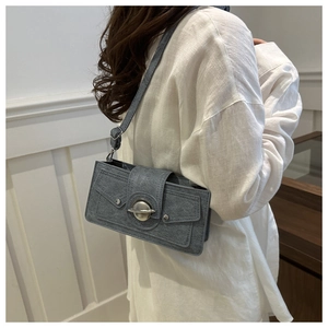 Side view of a vintage gray shoulder bag with large metal ring and strap on a model