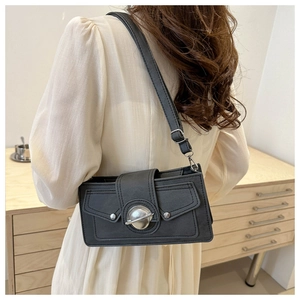 Detail view of a vintage dark grey square shoulder bag with a silver planet-shaped metal lock