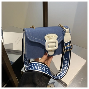 Detail der blauen Segeltuchtasche mit weißer Leder-Schnalle und breitem FASHION BAGS Gurt