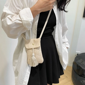Beige straw woven crossbody phone bag with trendy fringe detail and gold buckle strap