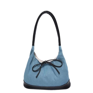 Blue denim trapezoid shoulder bag with black leather handle and stylish bow detail