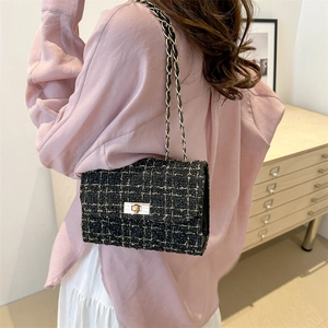 Classic black tweed crossbody bag with gold chain strap and rectangular metal turn-lock