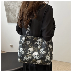 Detailaufnahme einer großen Gothic-Tragetasche mit Totenkopf- und Blumenprint am Model
