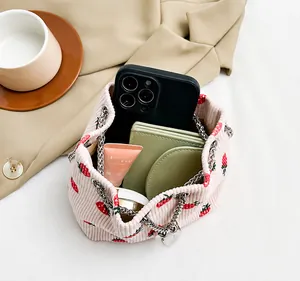 Interior view of pink strawberry corduroy bucket bag showing storage space for phone and makeup