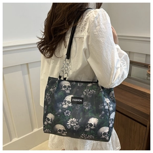Nahaufnahme der Canvas-Tasche mit Totenkopf- und Blumenprint sowie silbernen Kettendetails