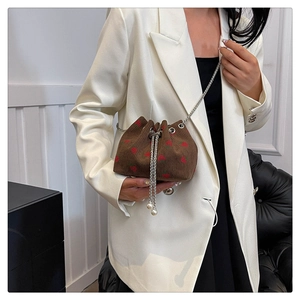Corduroy strawberry bucket bag with silver chain strap shown on white blazer outfit