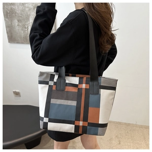 Close-up of geometric patchwork tote bag with high-capacity design and broad shoulder straps