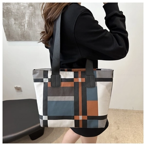 Detail of the multi-color geometric patchwork pattern on a large canvas tote bag