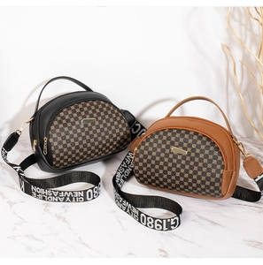 Detail of black and brown monogram shell bags with branded woven straps on marble