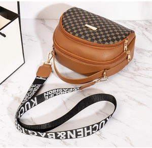 Close-up of brown PU leather bag with geometric patterns and wide jacquard strap