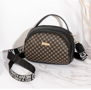 Detail of semicircular crossbody bag with embroidered pattern and woven shoulder strap