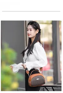 Outdoor street style model carrying a brown quilted crossbody bag with golden zippers