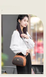 Close-up of quilted saddle bag with brown leather trim and stylish woven logo shoulder strap