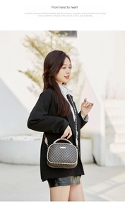 Detail of a brown monogram shell bag with beige piping and a stylish patterned wide strap