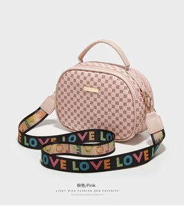 Pink crossbody bag detail showing retro round texture and LOVE print wide strap
