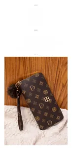 Detail of floral printed wallet with golden clover buckle and soft brown fur pompom
