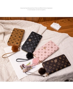 Close-up of elegant floral print long wallets with fluffy pompom charms in four colors