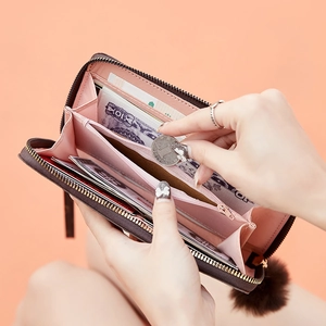 Detail view of the brown long wallet's interior slots, pink lining, and zip coin pocket