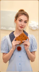 Brown leather coin purse with LBS monogram print and decorative faux fur pompom detail