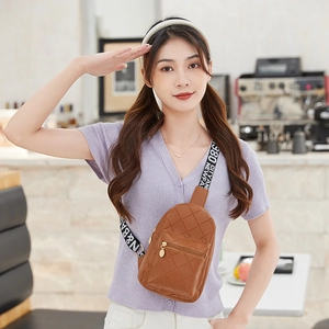 Brown quilted diamond pattern chest bag with lettered webbing strap worn by a model
