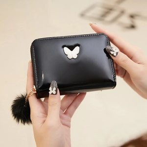 Portefeuille noir brillant pour femme avec décoration papillon et pompon en peluche