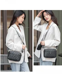 Détail d'un sac bandoulière matelassé noir avec large sangle et mini porte-monnaie