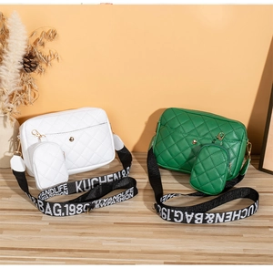 Détail de sacs bandoulière matelassés blanc et vert avec large sangle à lettres
