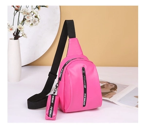 Detail der rosa PU-Leder Brusttasche mit Reißverschluss und kleinem Münzfach-Anhänger
