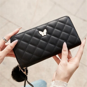 Black quilted long wallet for women with silver butterfly clasp and fuzzy pom pom charm
