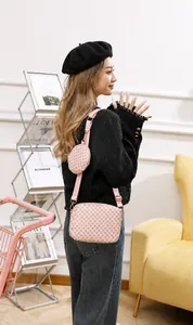 Pink crossbody bag with small round coin purse featuring geometric floral patterns