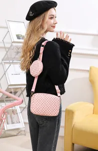 Detailed view of pink crossbody bag with geometric pattern and detachable mini round coin purse