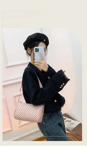 Detail of light pink cylindrical pillow bag featuring rhombus pattern and thin shoulder strap