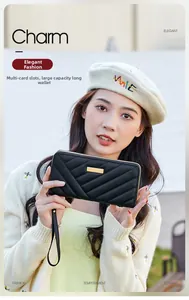 Detail of black quilted long wallet featuring V-stitch pattern and gold metal plate