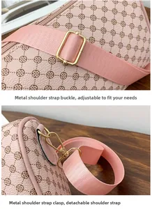 Detail of adjustable woven strap and gold metal hardware on pink floral patterned bag