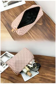 Detail showing spacious interior of pink floral cylinder bag with makeup and gadgets