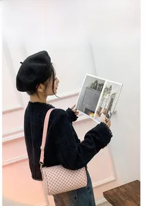 Detailed view of pink barrel bag with floral patterns on a model with black jacket
