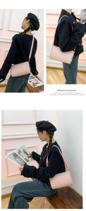 Detail of pink floral embossed crossbody bag with gold hardware and wide shoulder strap