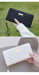 Detail of long quilted women's wallet with metal hardware and matching wrist strap