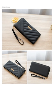 Detail view of black quilted long wallet with gold hardware and removable wrist strap