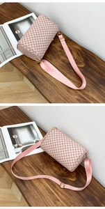 Detailed close-up of pink barrel bag with brown dot pattern and golden hardware