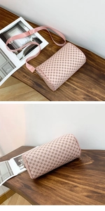 Detailed view of a pink cylinder pillow bag with floral pattern and wide strap
