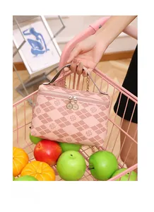 Close-up of pink checkered vanity bag with clover prints and gold chain in a pink cart