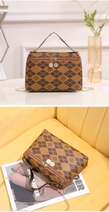 Detail view of contrast rhombic pattern and clover print on brown luxury handbag