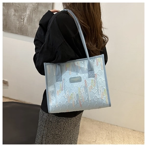 Detail view of light blue tote bag featuring vertical embroidery and embossed texture