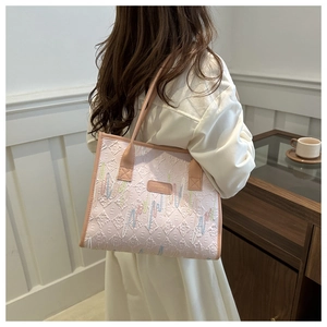 Detail of pink quilted tote bag featuring colorful embroidery and elegant PU leather texture
