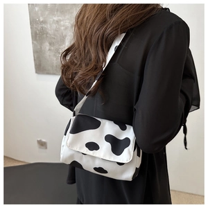 Detail of crossbody bag with black and white cow print texture and wide strap