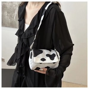 Detail of trendy cow print crossbody bag with high-quality stitching and flap texture