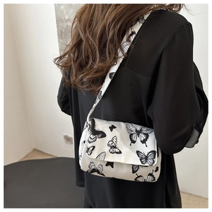 Detailed back view of a medium white crossbody bag featuring black butterfly prints